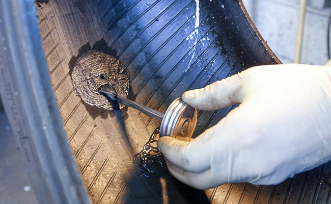 Tech applying vulcanizing glue to tire