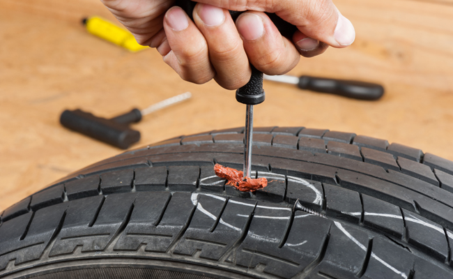 Technician inserting a tire plug